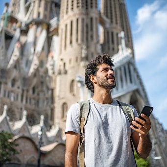 Man in Barcelona looking at the Travelex Money App on his phone