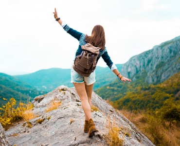 trekker walking on a rock