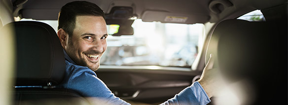 man smiling driving his car