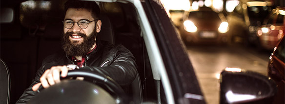 man smiling driving in a car